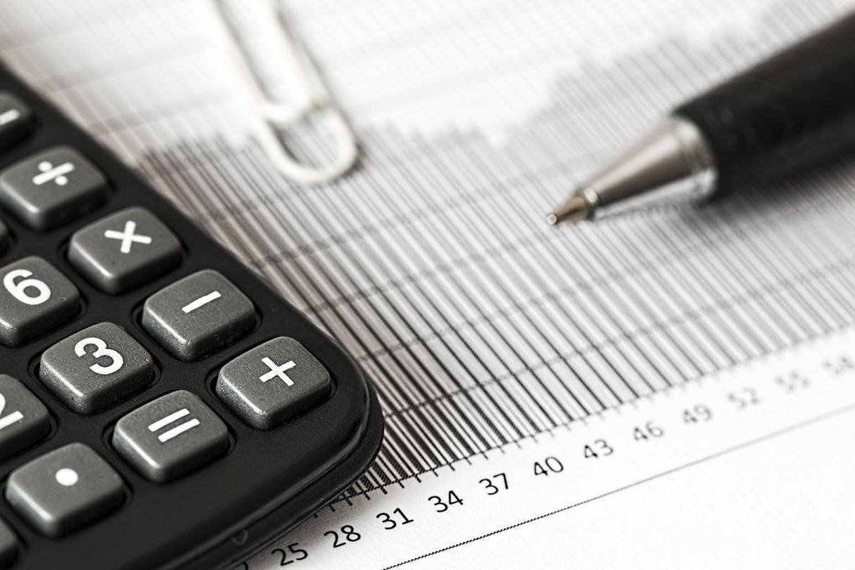 Escritorio con billetes, calculadora y una laptop para gestión financiera